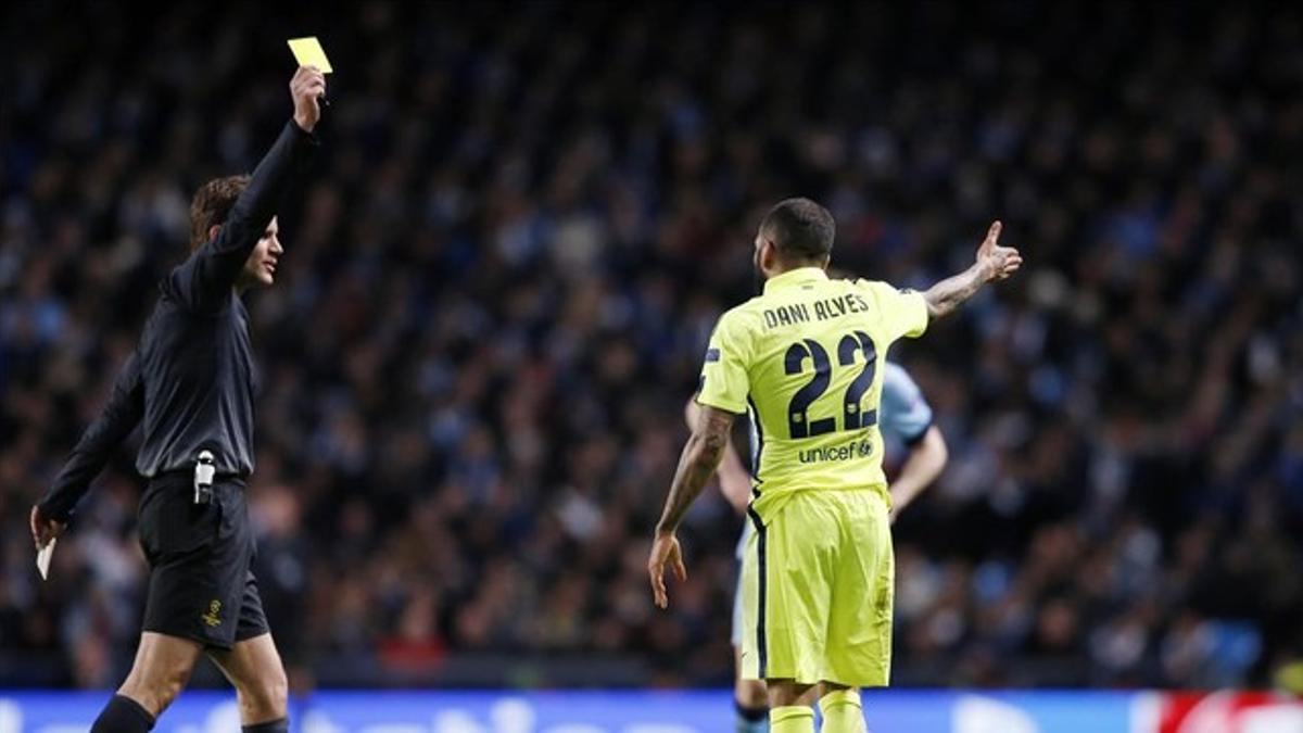 Felix Brych amonesta a Dani Alves en el campo del Manchester.