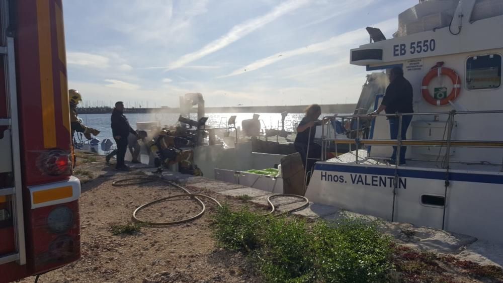 Los bomberos extinguen el fuego en un barco pesquero en Torrevieja