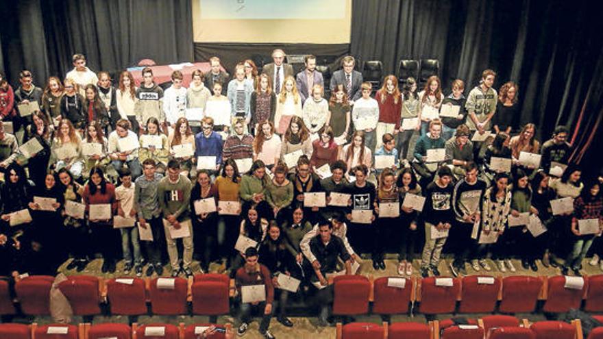 Foto de familia de los 85 estudiantes premiados con las autoridades que les entregaron la distinción sobre el escenario.