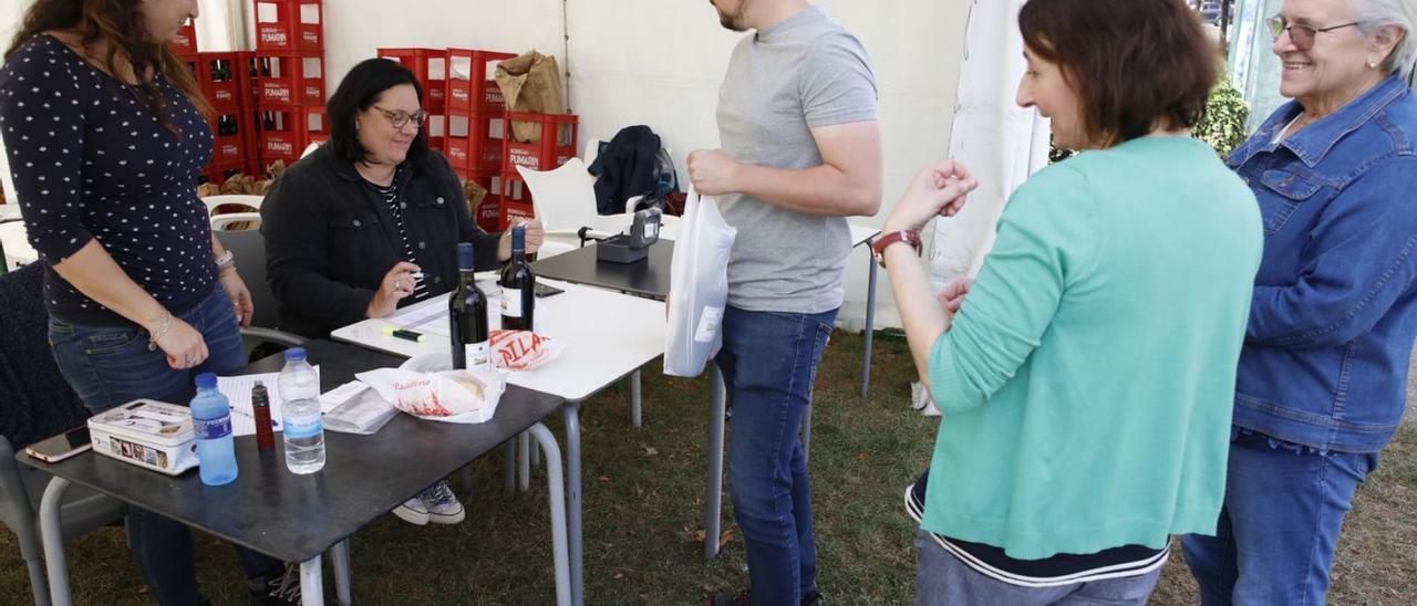 Vecinos, ayer, recogiendo el bollo en las fiestas de Pumarín. | Ángel González