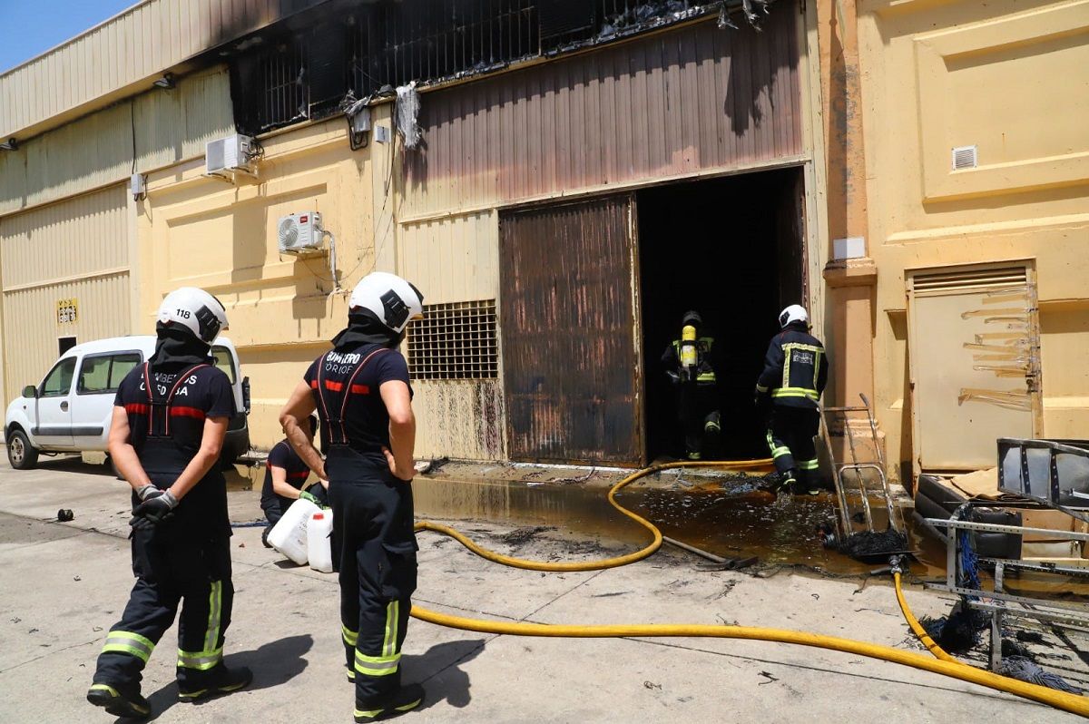 Bomberos de Córdoba en el exterior de la nave de las Quemadas donde se ha reactivado un incendio apagado horas antes.
