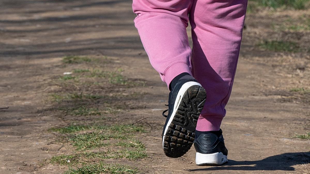 Una mujer camina por un parque.