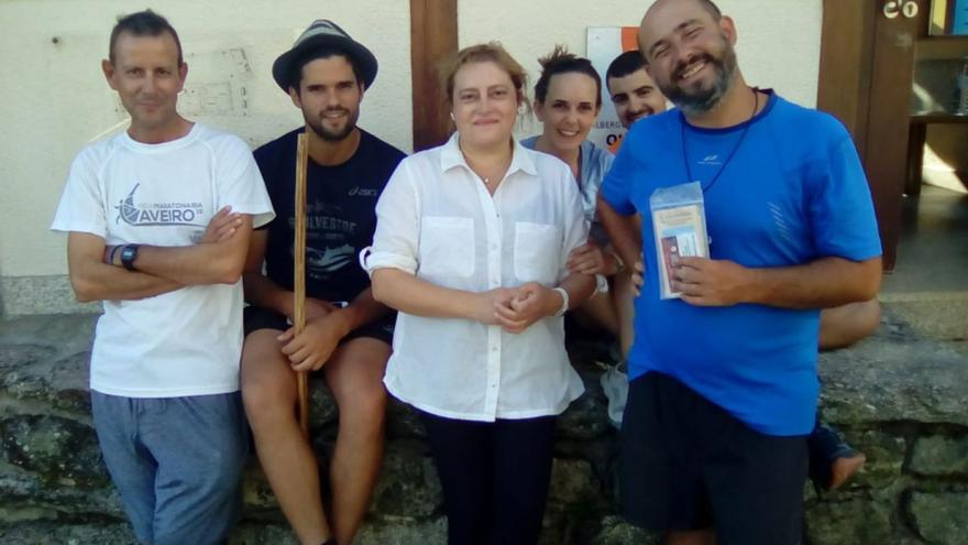 Puri Carreira, hospitaleira do albergue público de Olveiroa, no centro, cun grupo de peregrinos / |  ALBERGUE DE OLVEIROA