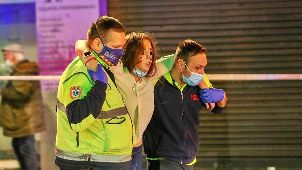 Sanitarios trasladan a una mujer tras un incendio en Valencia.