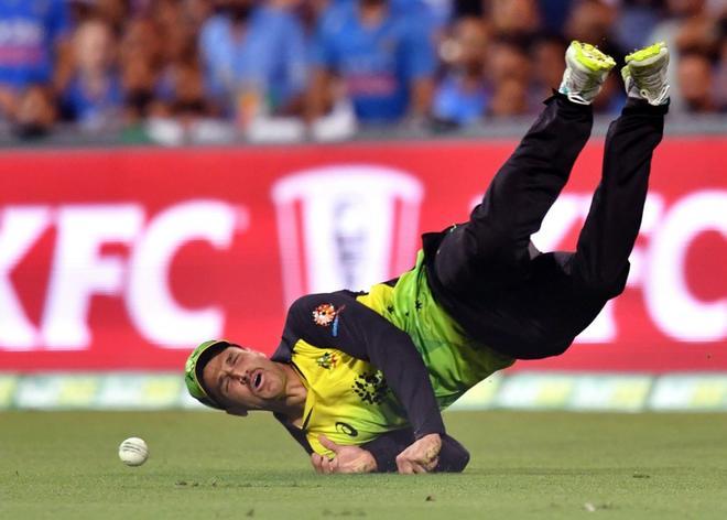 El jugador australiano de críquet Nathan Coulter-Nile cae al suelo durante el primer partido del torneo internacional Twenty20 entre Australia y la India en el estadio Gabba en Brisbane.