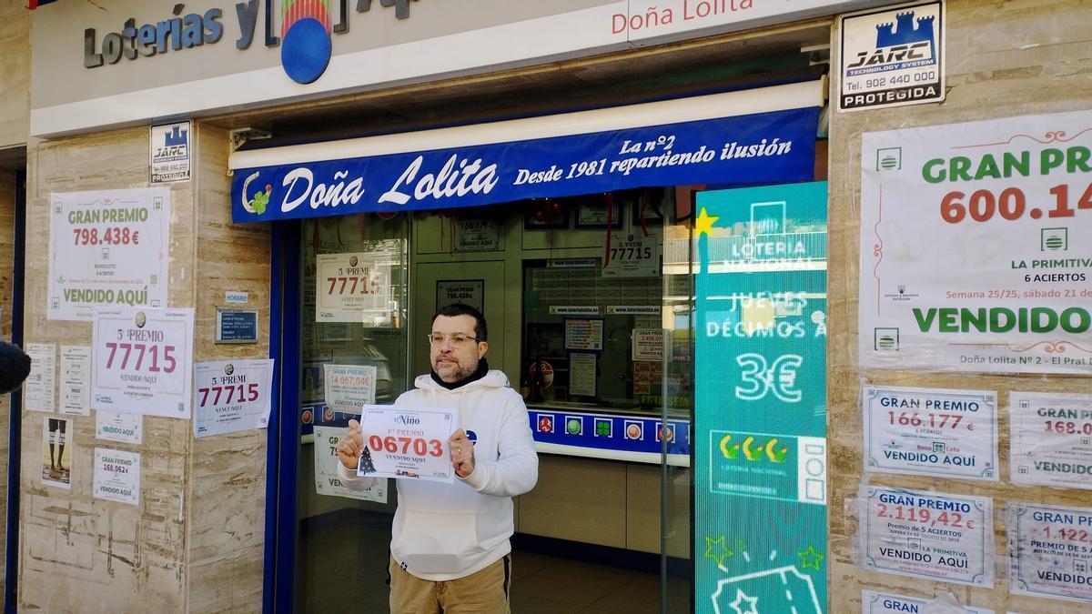 Santiago Martín, dueño de la administración de lotería Doña Lolita de El Prat de Llobregat, posa con el primer premio de El Niño de 2026.