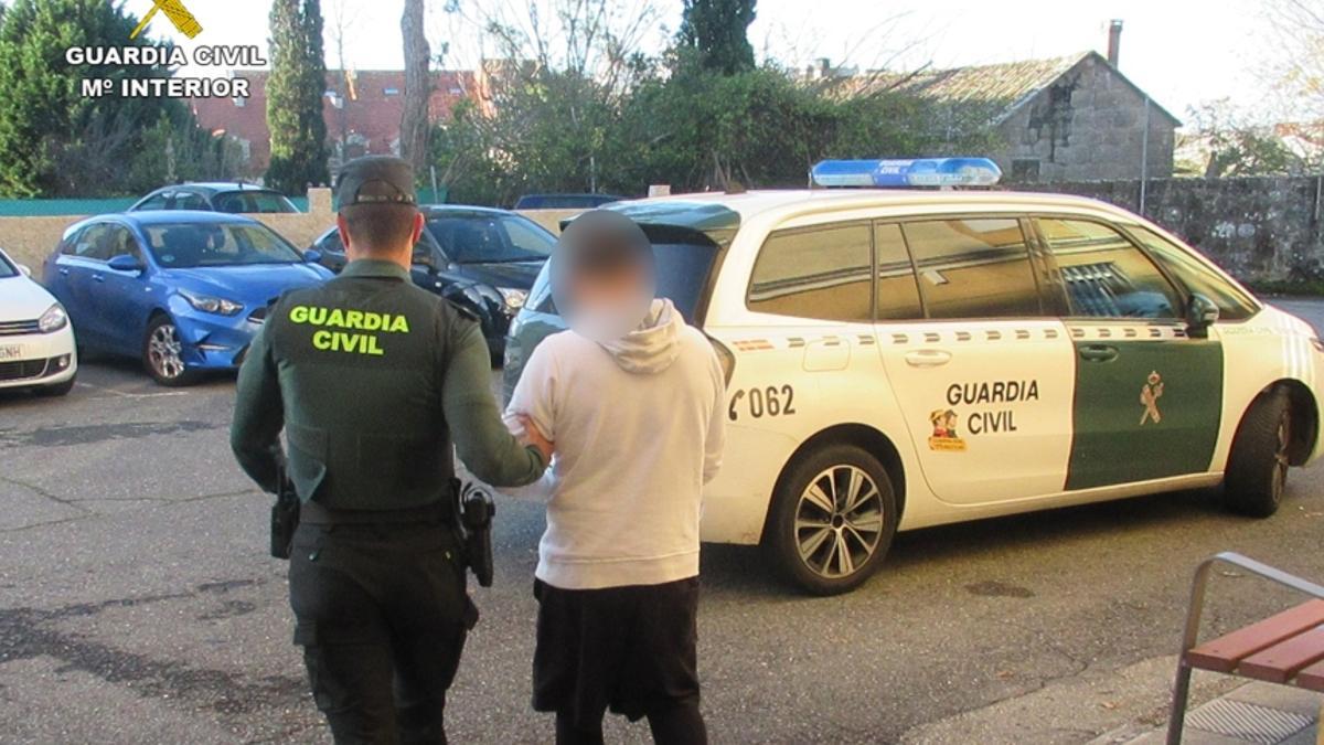 Un agente conduce al detenido