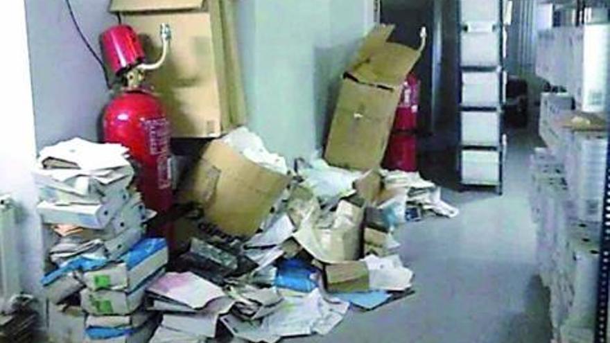 Imágenes del interior de los juzgados de Vigo, con papeles cubriendo un extintor, cajas en un baño y armas apiladas en el archivo junto al resto de piezas de convicción.