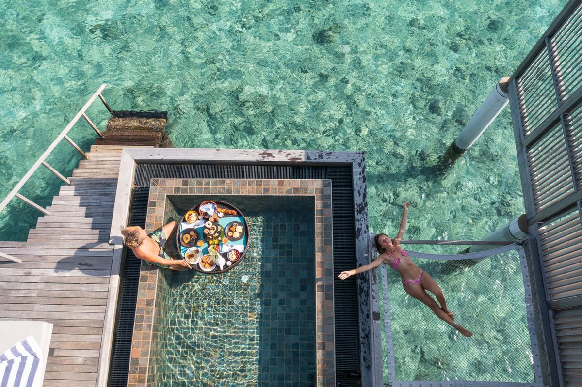Un desayuno flotante en Maldivas consiste en disfrutar de una bandeja de madera (a veces con forma de corazón) repleta de fruta fresca, bollería, zumos y platos calientes, que se sirve directamente sobre el agua de la piscina privada de tu villa