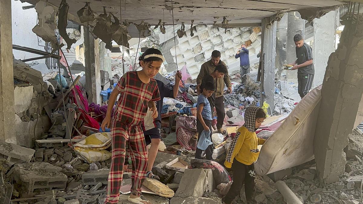Variso niños caminan entre los escombros tras un ataque de Israel en Gaza.