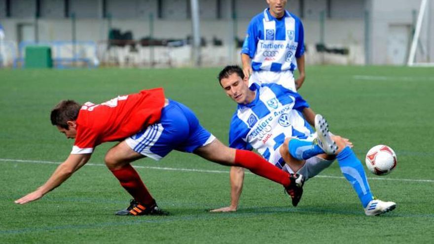 Un defensa del Lugones se lleva el balón tras una entrada.