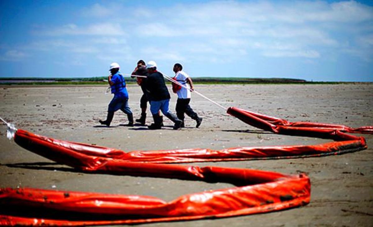 Temor. Un grup de treballadors preparen barreres de contenció a les platges de Louisiana (EUA) davant la imminent arribada del cru.