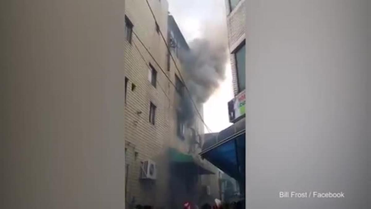 Una dona llança els seus tres fills per la finestra per salvar-los del foc.