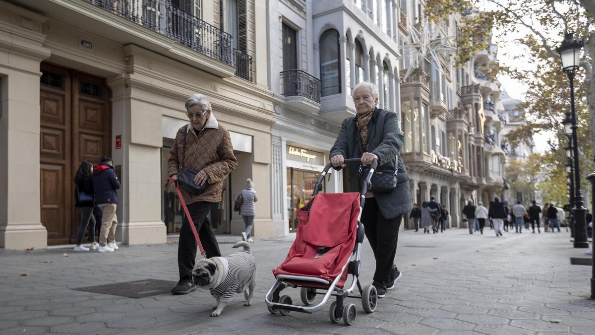 Una mujer empuja el carrito de la compra por el paseo de Gràcia, una escena prácticamente insólita.