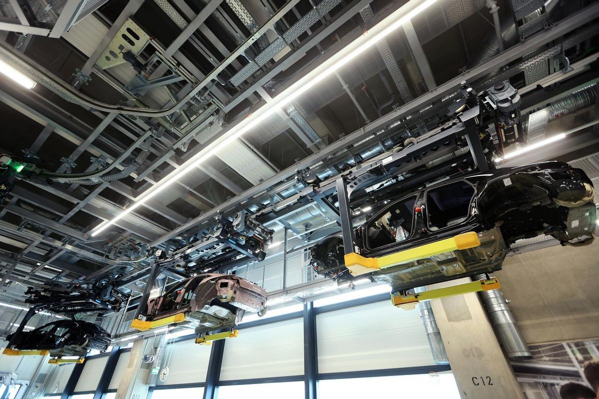 Los empleados trabajan en las carrocerías de los automóviles de lujo Porsche Taycan totalmente eléctricos en la línea de producción de la fábrica de Porsche AG en Stuttgart, Alemania.