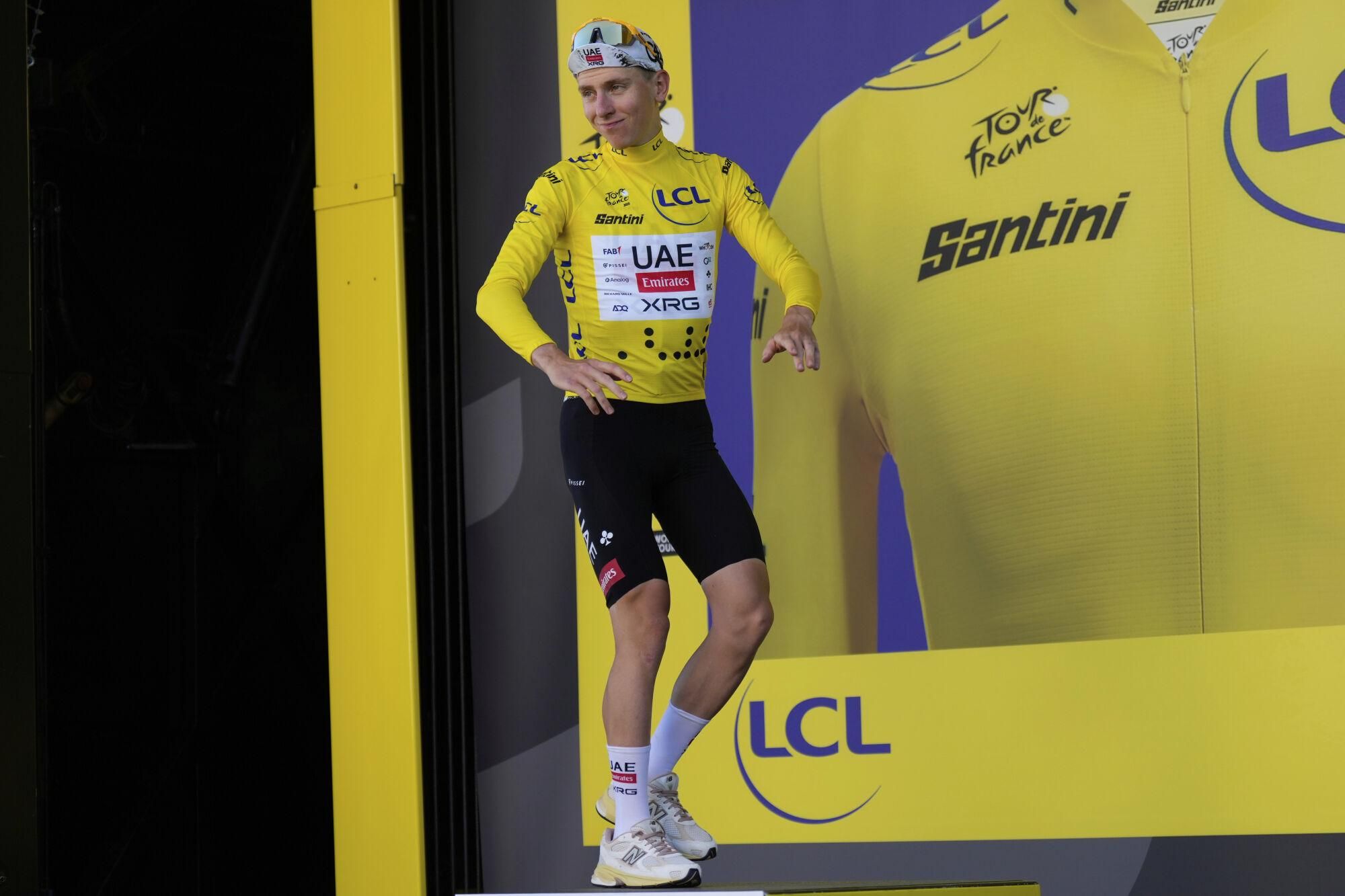 Slovenia's Tadej Pogacar wearing the overall leader's yellow jersey arrives on the podium after the fifth stage of the Tour de France cycling race, an indivdual time-trial over 33 kilometers (20.5 miles) with start and finish in Caen, France, Wednesday, July 9, 2025. (AP Photo/Mosa'ab Elshamy)