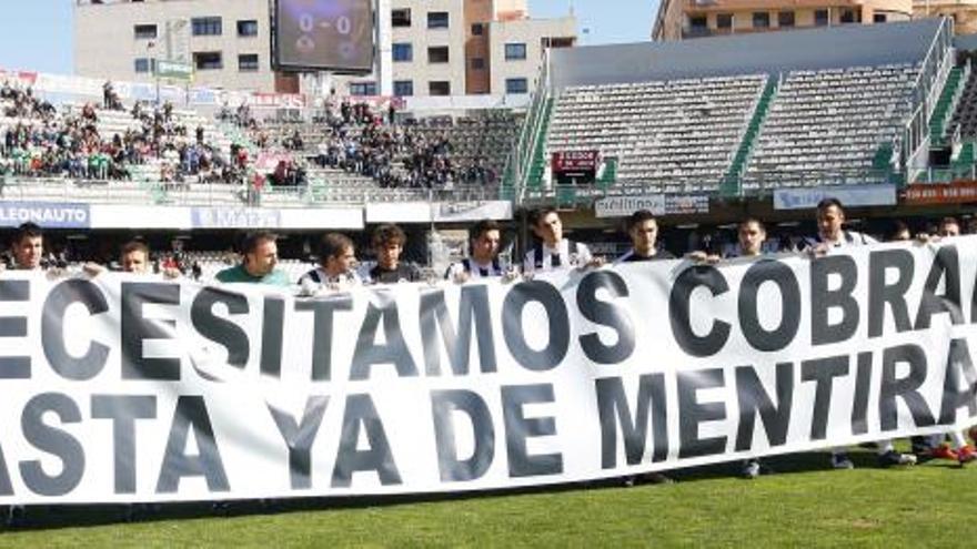 Los futbolistas del Castellón exhiben una pancarta de protesta antes de un encuentro.