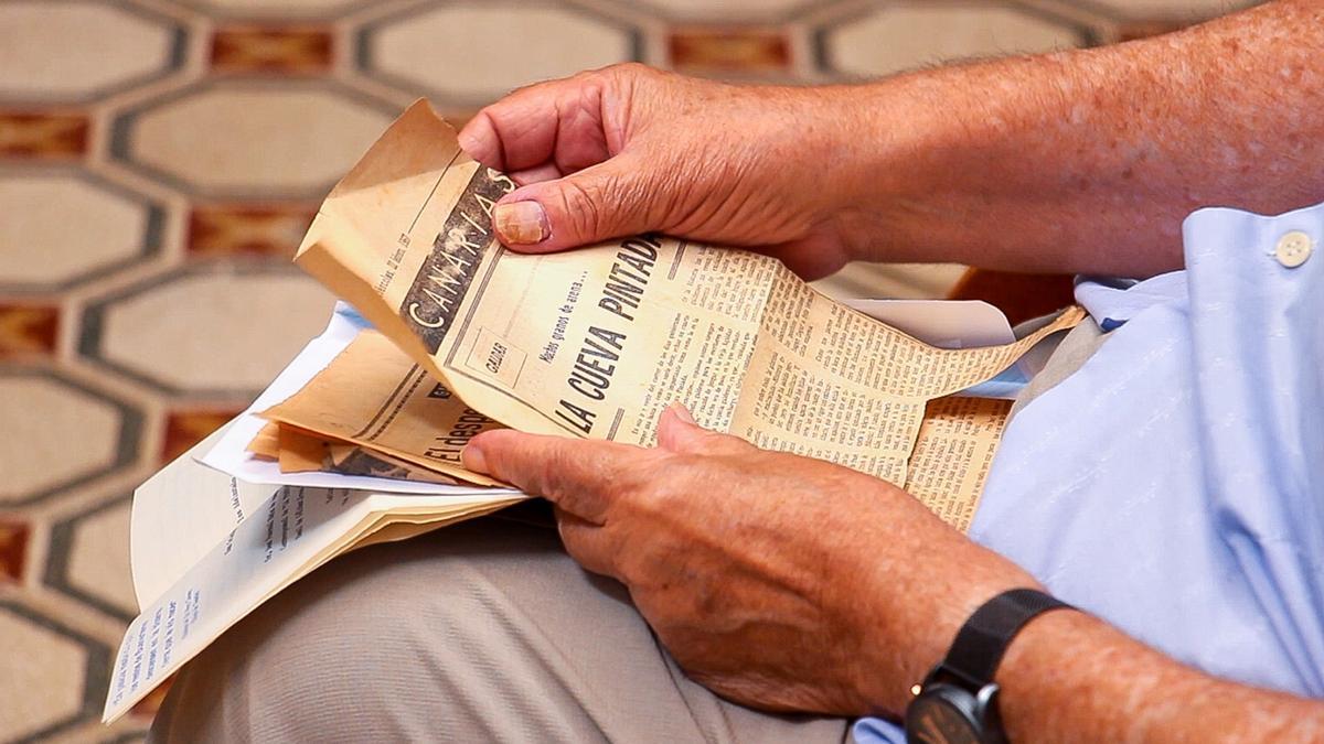 Antiguos recortes de periódico en las manos de Pascual Ruiz Quesada