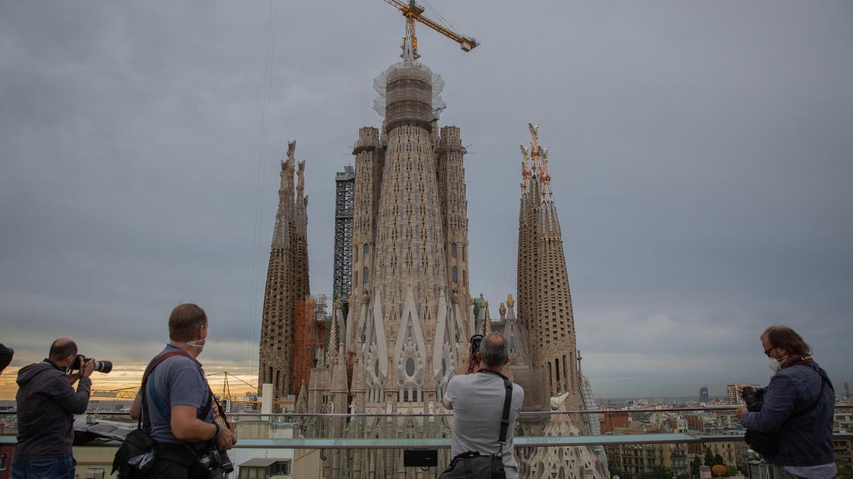 Archivo - Varias personas fotografían la construcción de la torre de la Madre de Dios de la Sagrada Familia