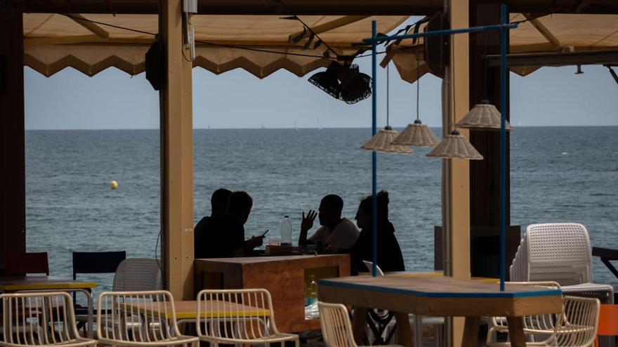 Varias personas conversan en una terraza en Barcelona