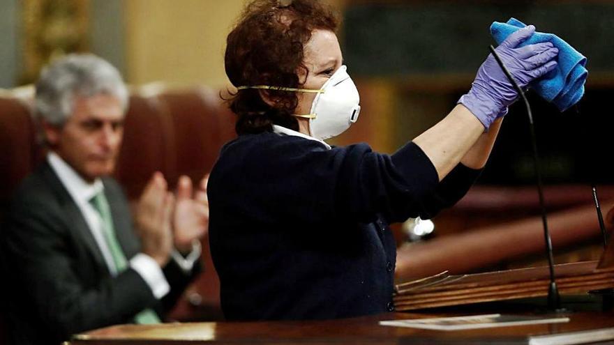 Valentina, empleada de limpieza en el Congreso, desinfecta la tribuna durante el pleno de ayer.