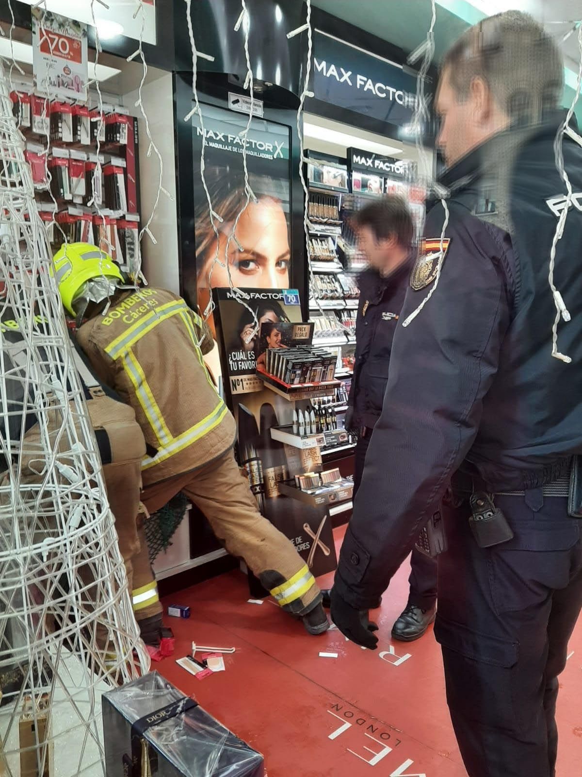 Bomberos y policías tratando de buscar al animal en el interior de la perfumería Aromas.