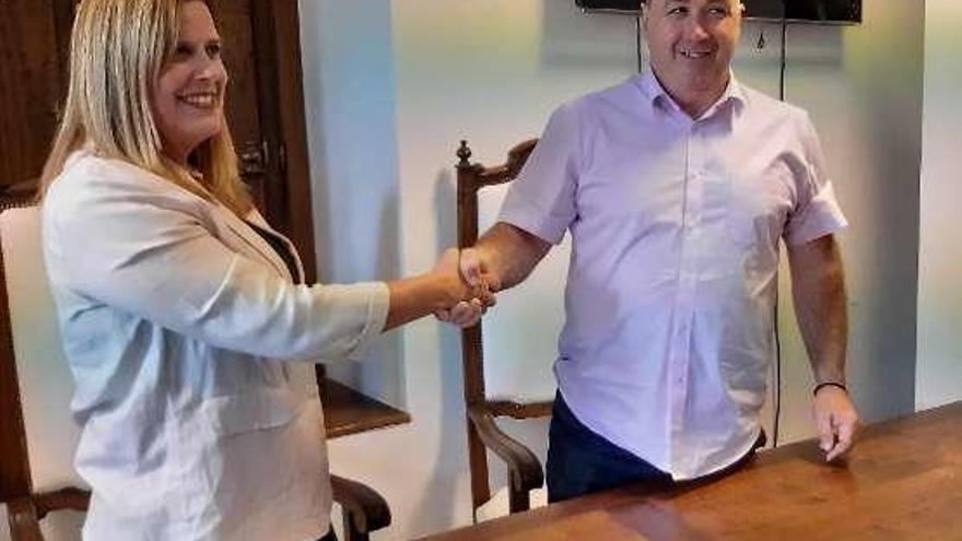 Carmen Arbesú y José Ángel Álvarez &quot;Quirós&quot; se estrechan la mano tras la firma del convenio.