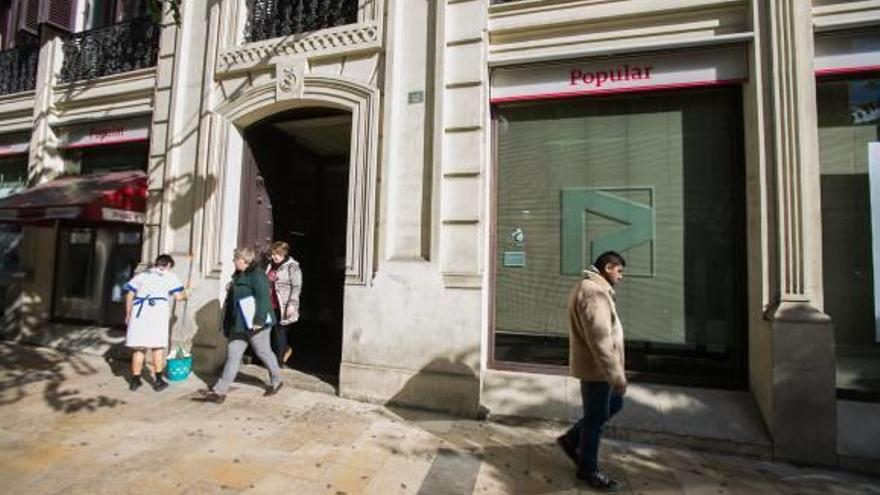 Clientes a la salida de una sucursal bancaria de Alicante, ayer.