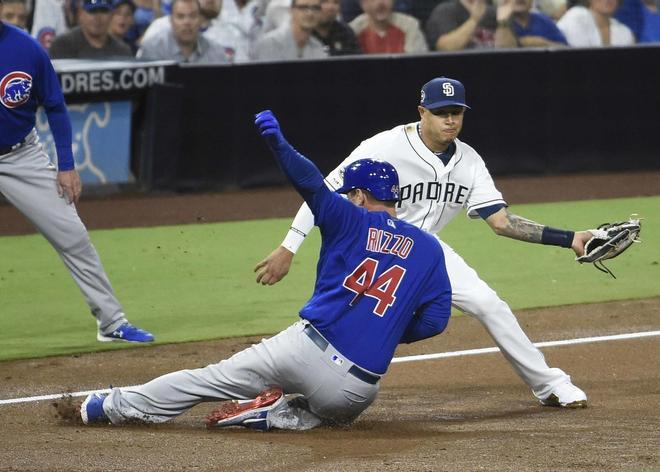 Anthony Rizzo # 44 de los Chicago Cubs se desliza a la tercera base con un triple por delante de la etiqueta de Manny Machado # 13 de los Padres de San Diego durante la segunda entrada de un juego de béisbol en Petco Park en San Diego, California.