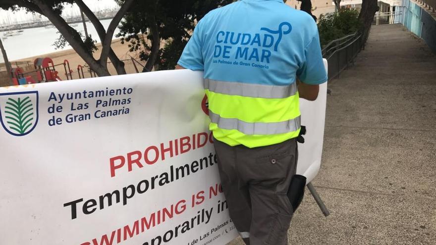 Trabajadores de Ciudad de Mar retirando los carteles de prohibido el baño esta mañana