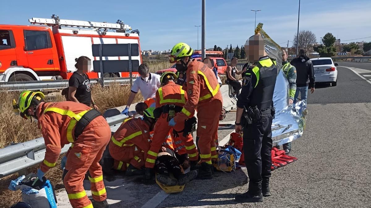 Los bomberos y los efectivos sanitarios atienden a los dos motoristas heridos en Torrent.