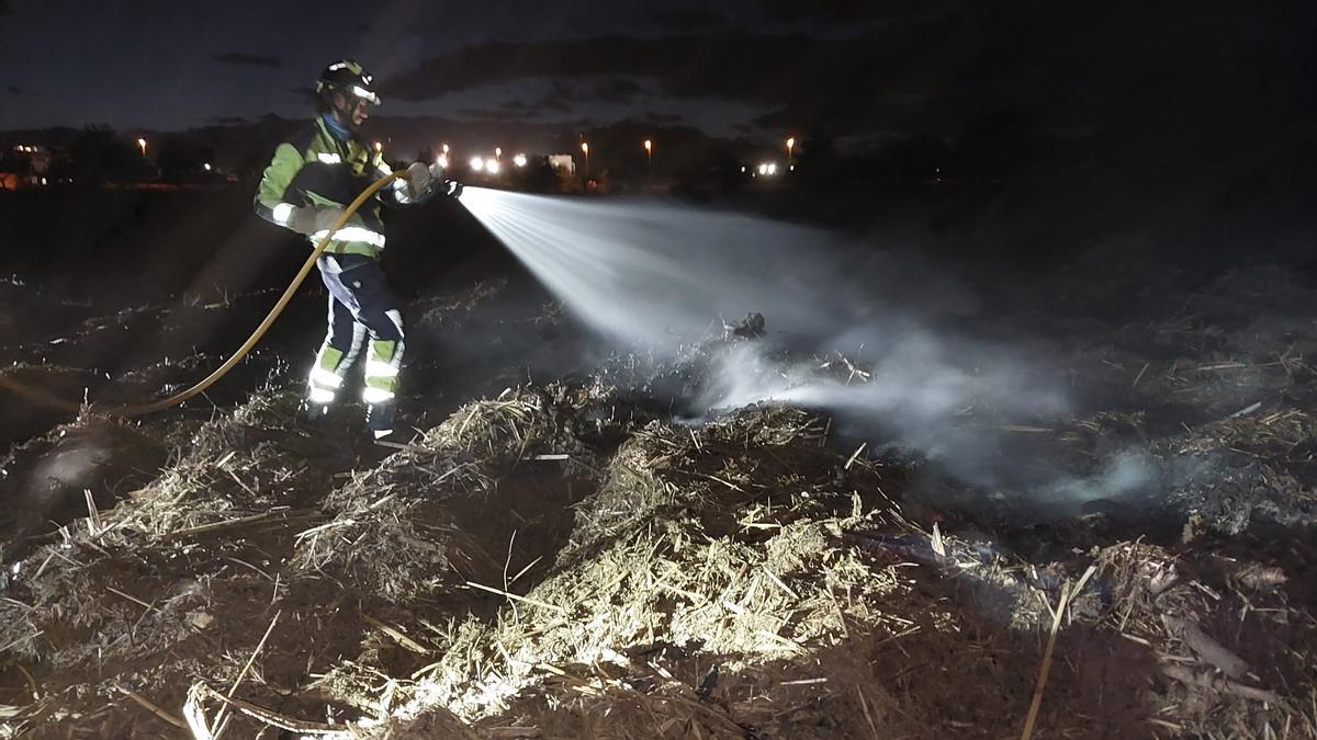 Un bombero apaga las llamas en la quema de rastrojos descontrolada
