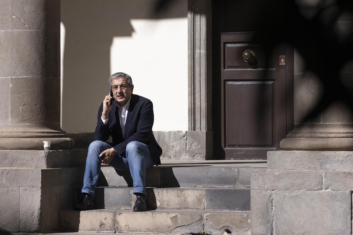 Román Rodríguez habla por teléfono en el patio del Parlamento de Canarias