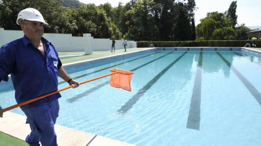 Un operario prepara la piscina antes del inicio de la pasada temporada.