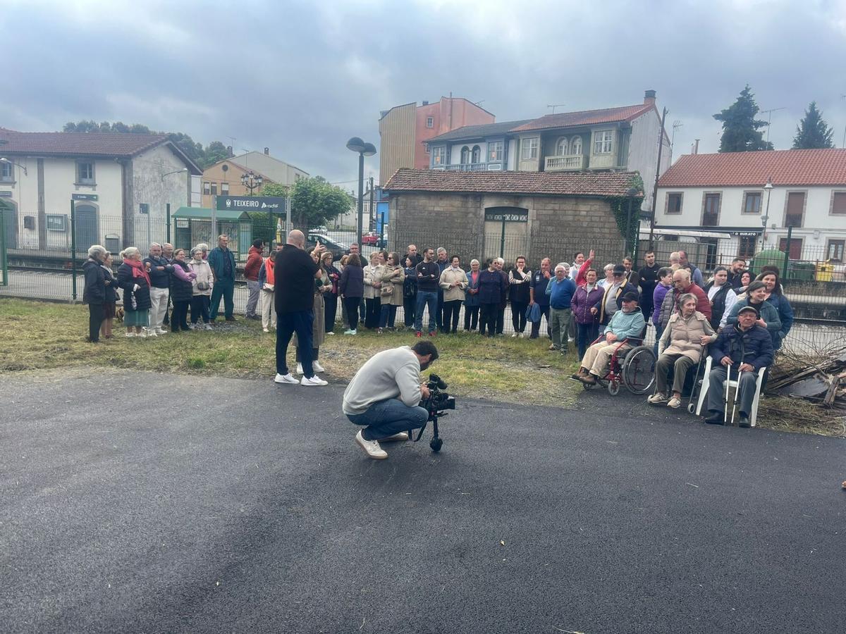 Residentes en Teixeiro, ayer, junto al nuevo vallado de la estación de tren. // La Opinión