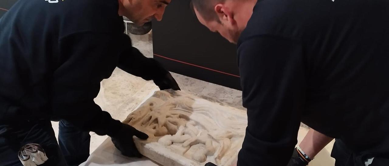 Los operarios de una empresa especializada recogiendo la tapa del sarcófago de Jonás en el Museo Arqueológico de Elda.