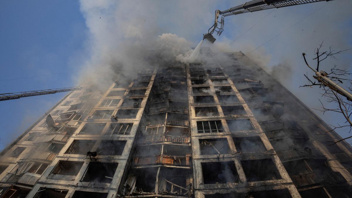 Firefighters work to put out a fire in a residential apartment building after it was hit by shelling in Kyiv