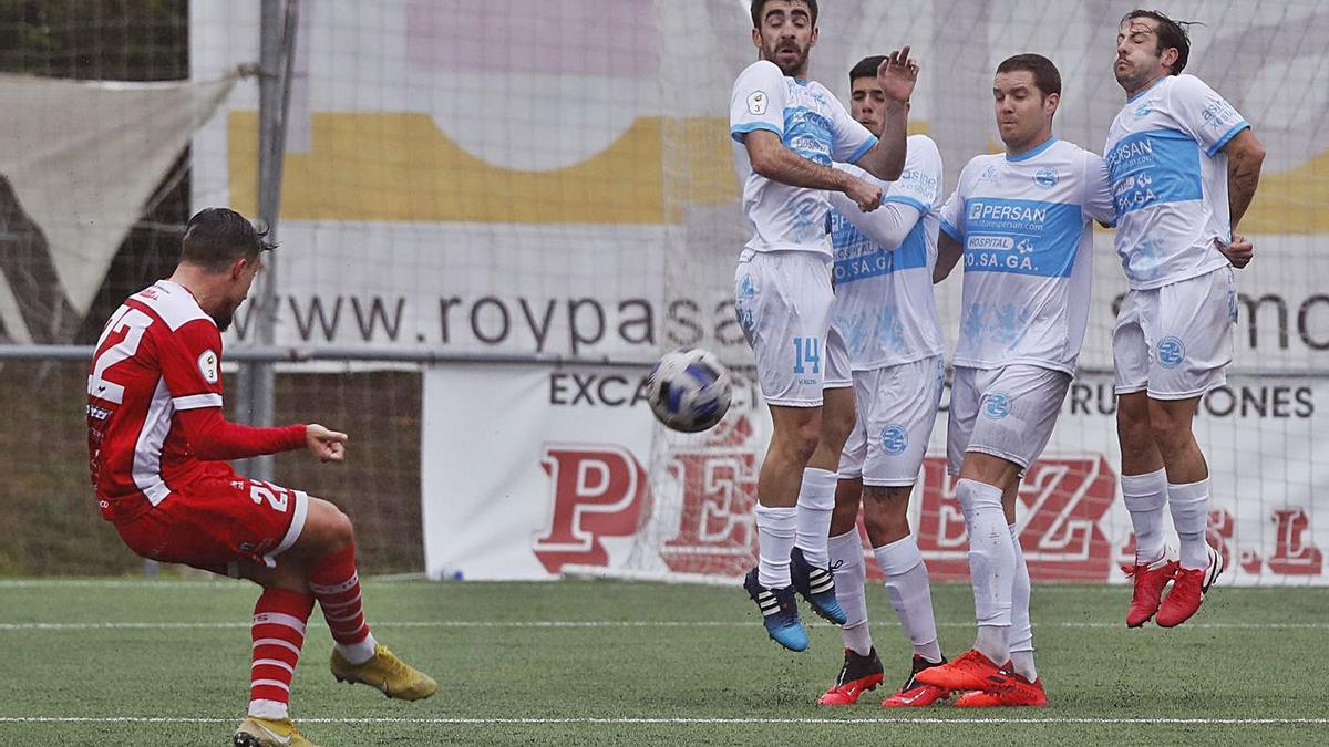 La barrera ourensanista intenta repeler el lanzamiento del futbolista del Atios Sergio de Paz. |   // R.G.