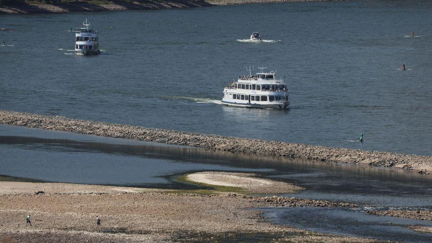 La parte más seca del río Rin permite el paseo a pie mientras los barcos turísticos todavía pueden navegar en Bingen, Alemania.