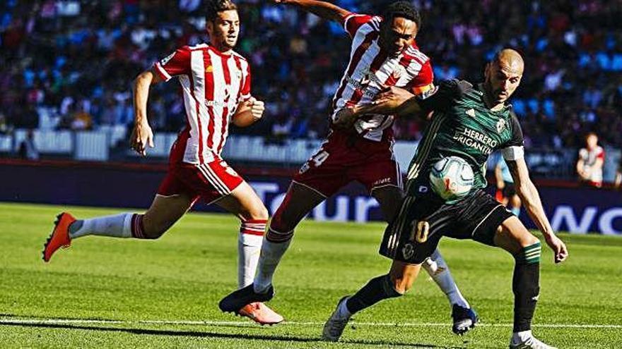 Yuri protege el balón ante un jugador del Almería.