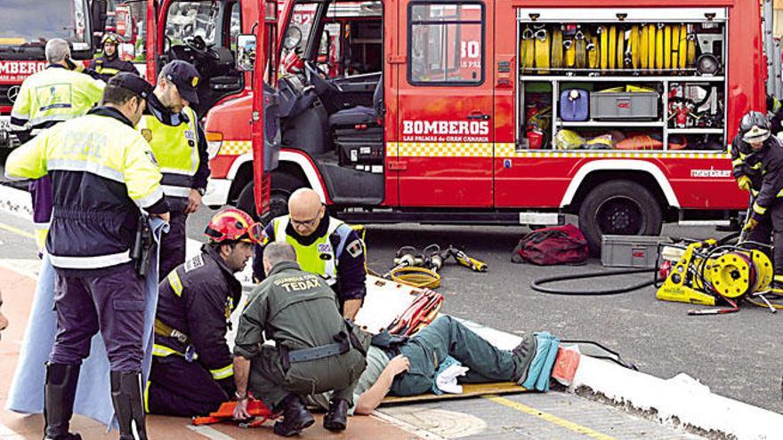 Bomberos y agentes, con otro de los afectados por la colisión.