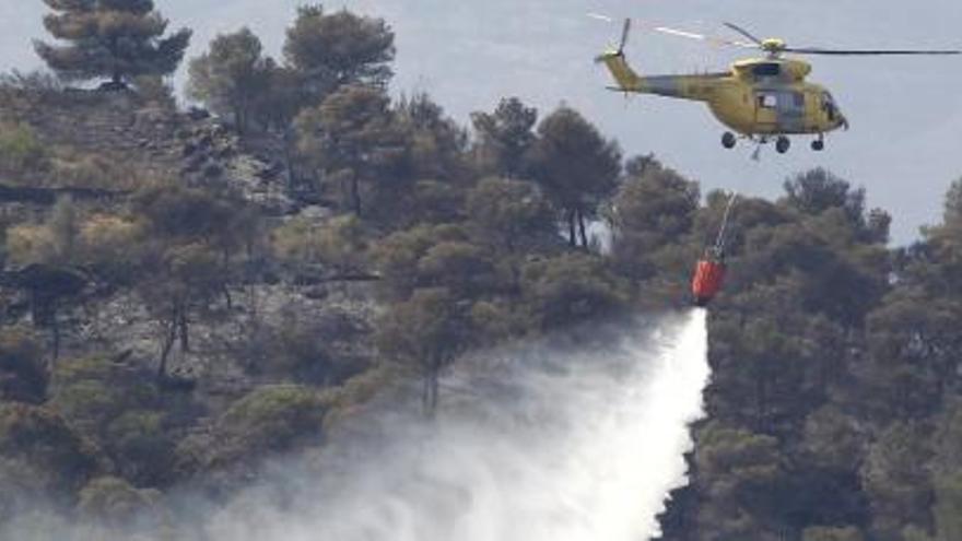 Un helicóptero lanza agua a la montaña en Macastre, hoy.