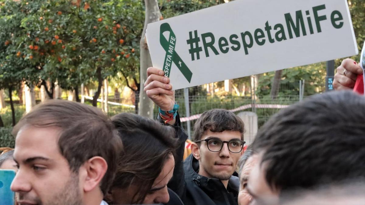 Un joven contrario a la retirada de la cruz se manifiesta en el Parque Ribalta ante el inminente traslado.