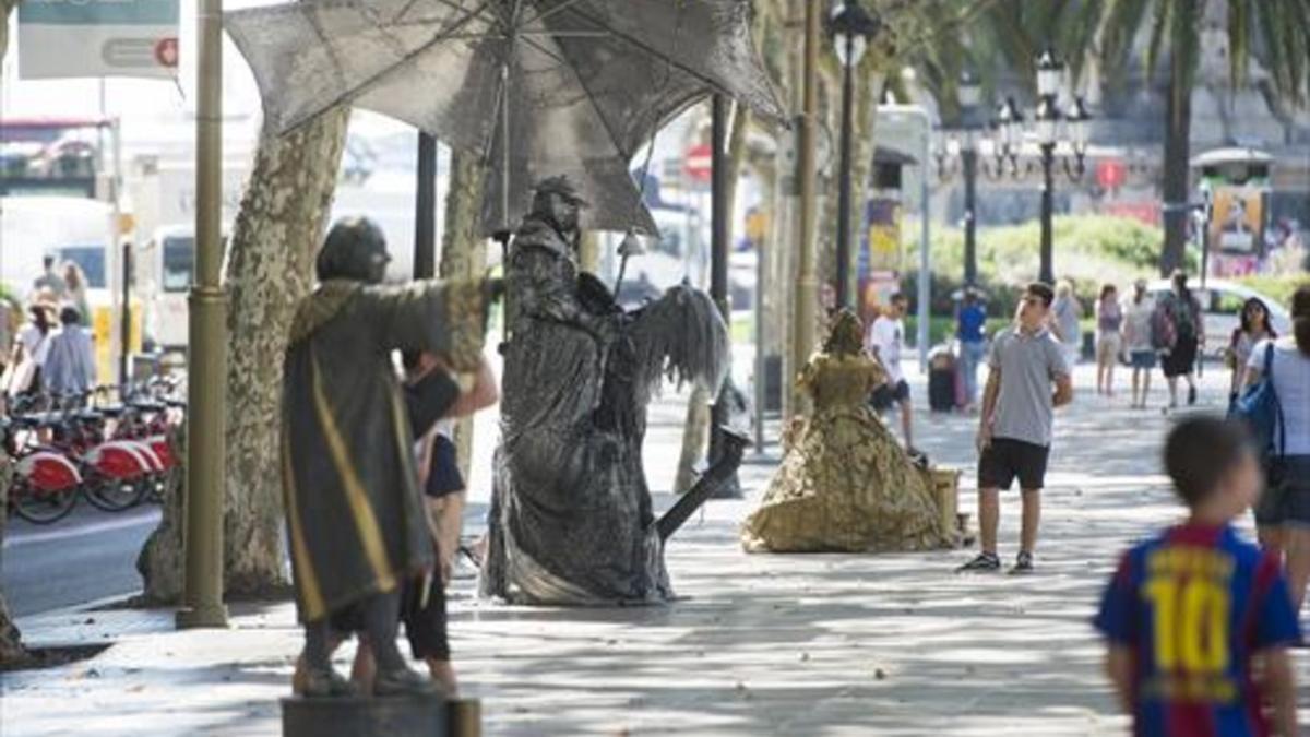 Dos imágenes de las estatuas humanas que trabajan actualmente en la Rambla, el pasado lunes.