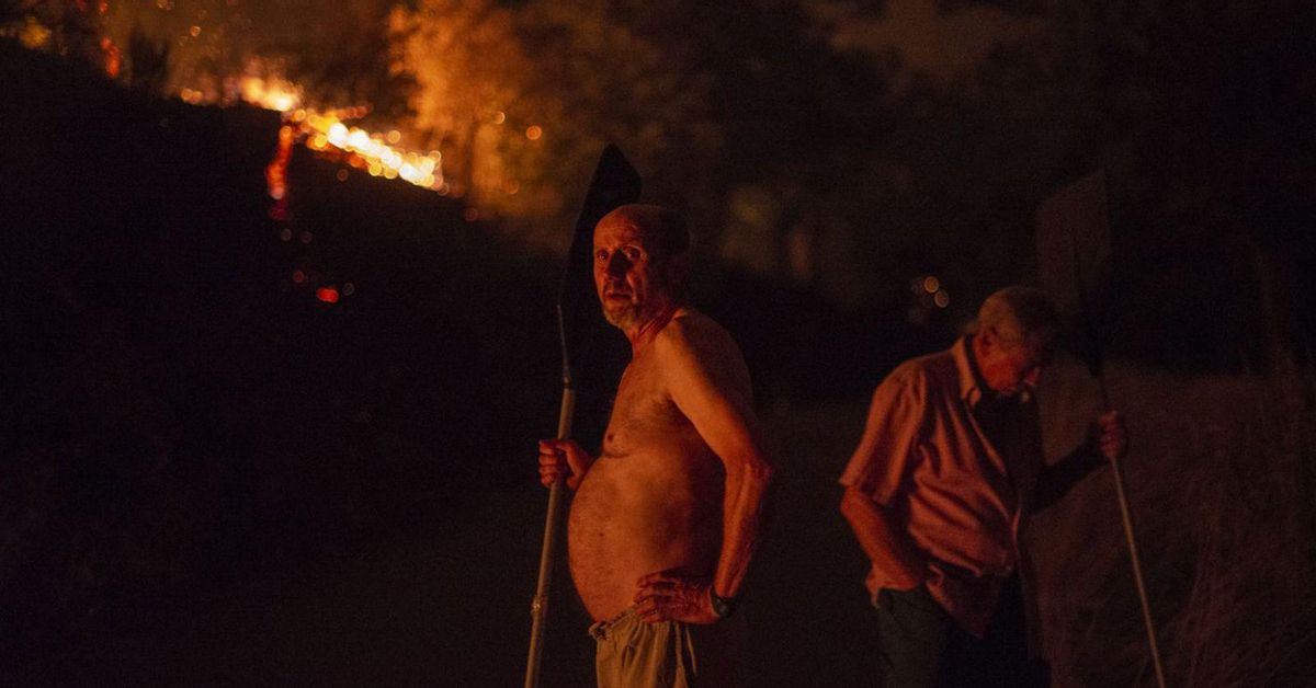 Dos vecinos de Alixo observan, durante la madrugada, las llamas en el pueblo. | // BRAIS LORENZO