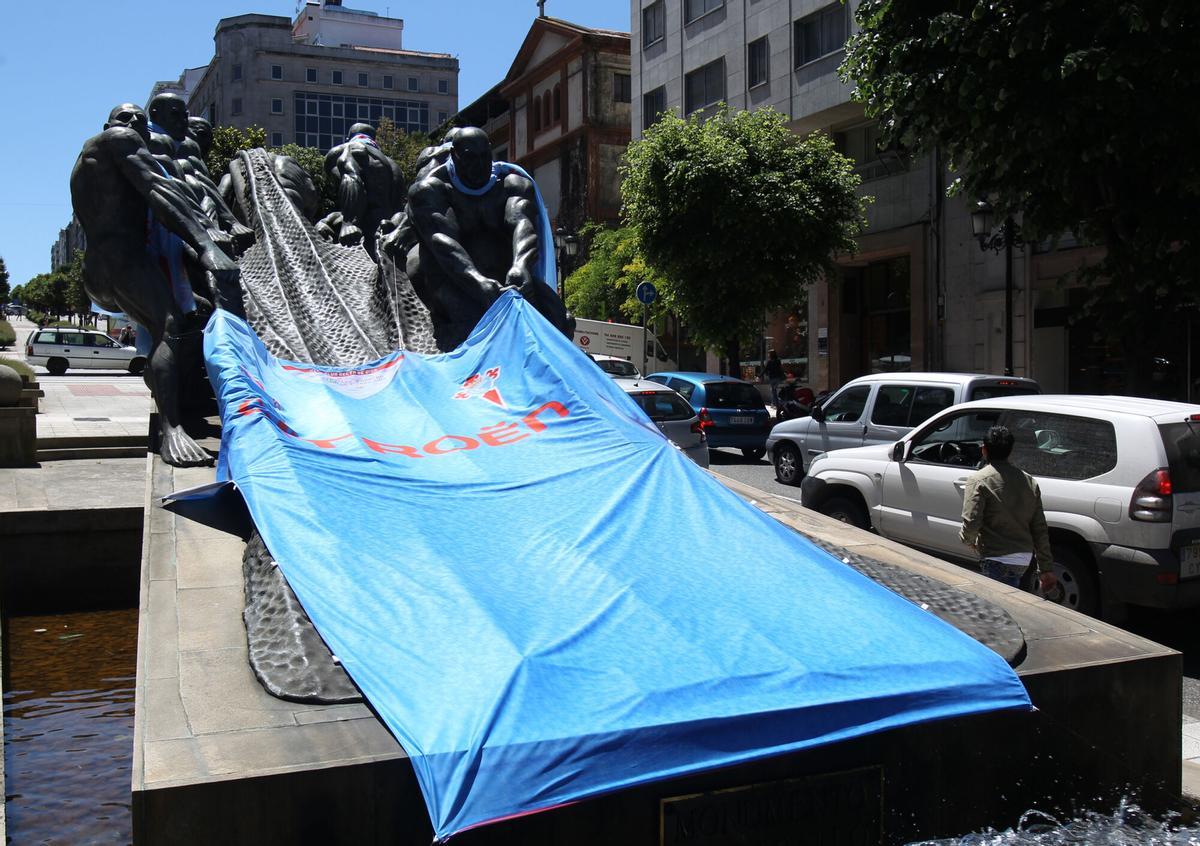 MONUMENTOS DE VIGO CON BUFANDAS, BANDERAS O CAMISETAS DEL REAL CLUB CELTA DE VIGO, INICIATIVA DEL CONCELLO DE VIGO PARA APOYAR A DICHO EQUIPO EN EL ULTIMO PARTIDO DE PRIMERA DIVISION DE LA TEMPORADA 2012 - 2013, EN EL QUE SE JUEGA LA PERMANENCIA EN LA CATEGORIA. EN IMAGEN, MONUMENTO "LOS REDEROS" EN LA AVENIDA GRAN VIA DE VIGO , OBRA DEL ESCULTOR RAMON CONDE. FUTBOL. LIGA. ARTE. ESCULTURA. MONUMENTO AL TRABAJO