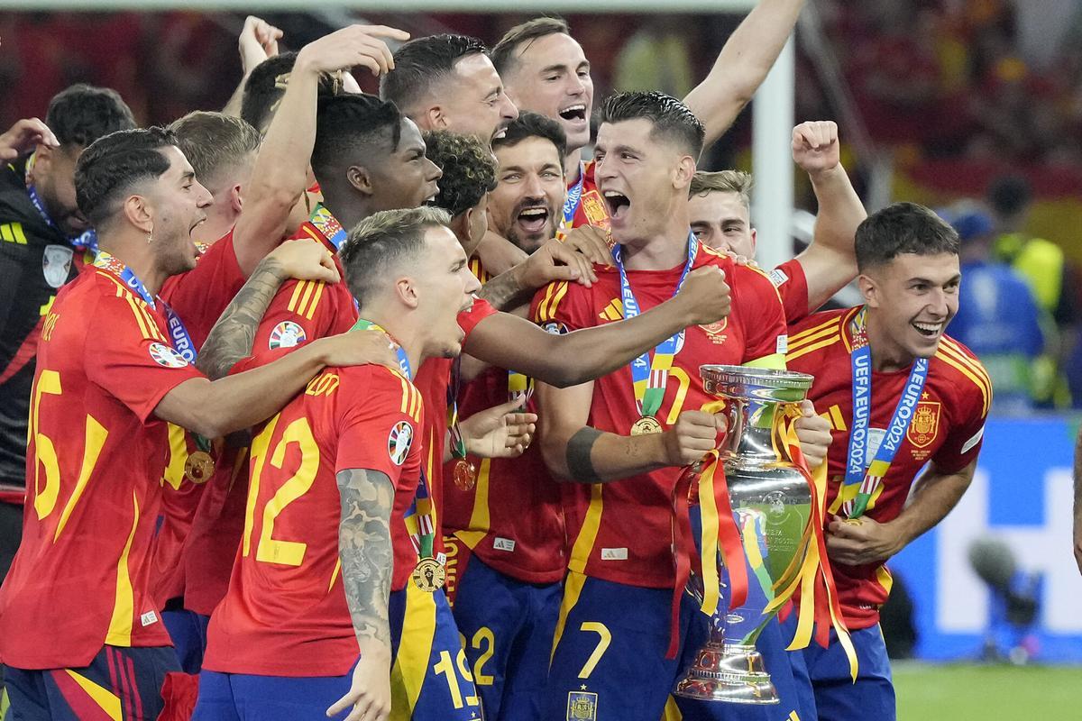 Spain's captain Alvaro Morata holds the trophy, when Spain players celebrate winning the Euro 2024 soccer tournament after the final match between Spain and England in Berlin, Germany, Sunday, July 14, 2024. (AP Photo/Martin Meissner)