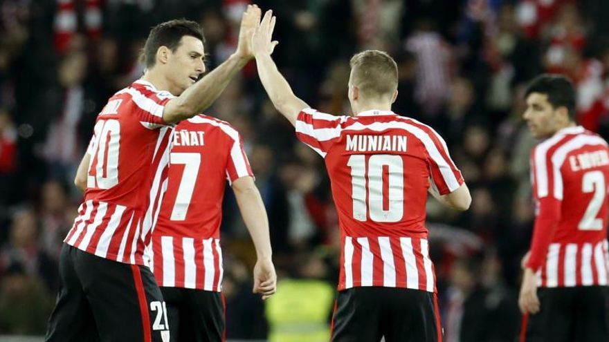 Aduriz y Muniain se chocan la mano tras una jugada.