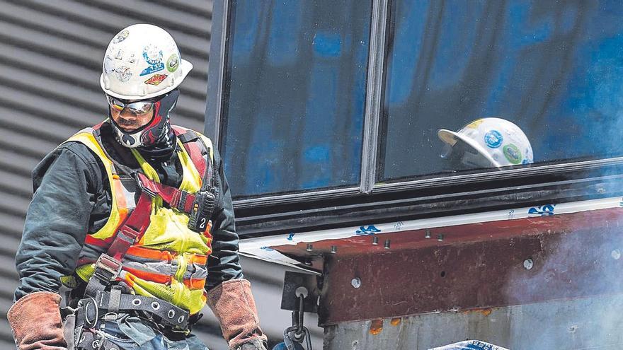 Una pareja de obreros, en un andamio, durante su jornada laboral.