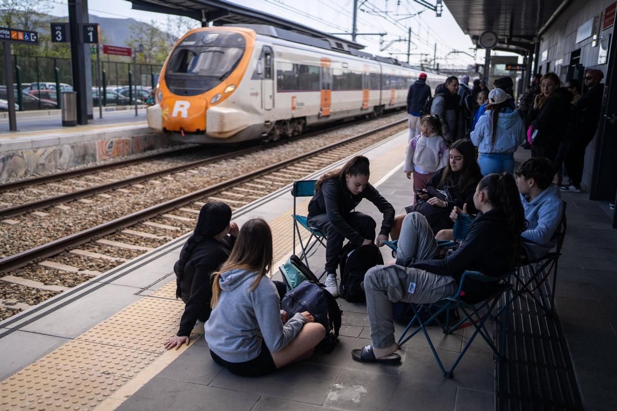 Usuarios de Rodalies esperan al tren patra ir a la playa de Badalona